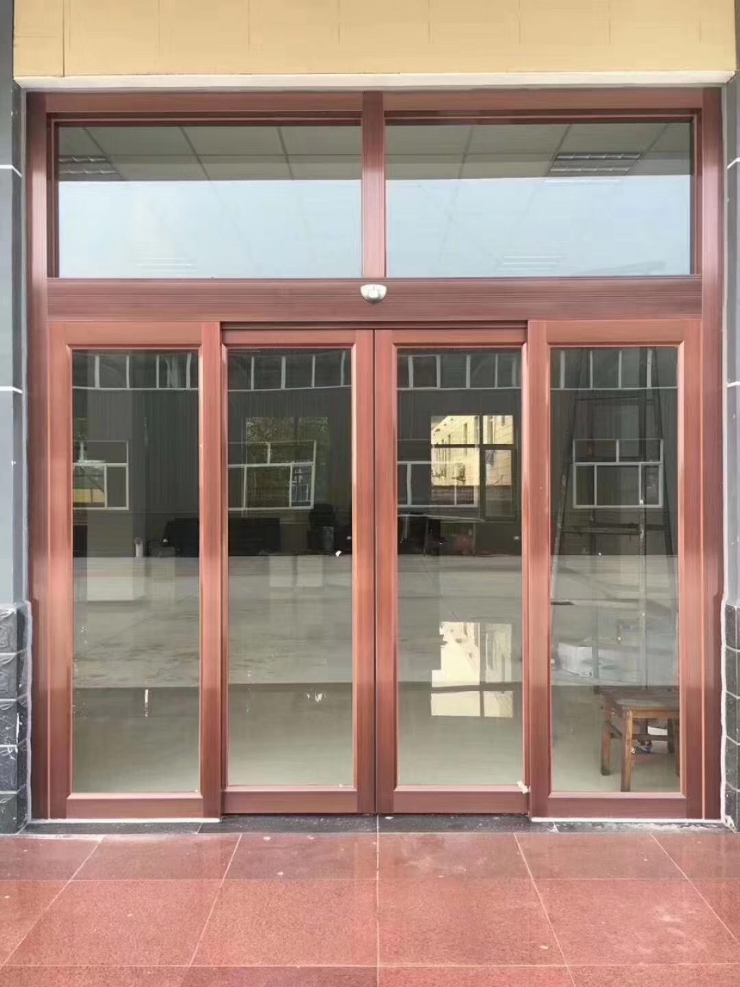 木纹框玻璃门:门店入口的木纹色框双扇玻璃自动门,门头保留招牌位置