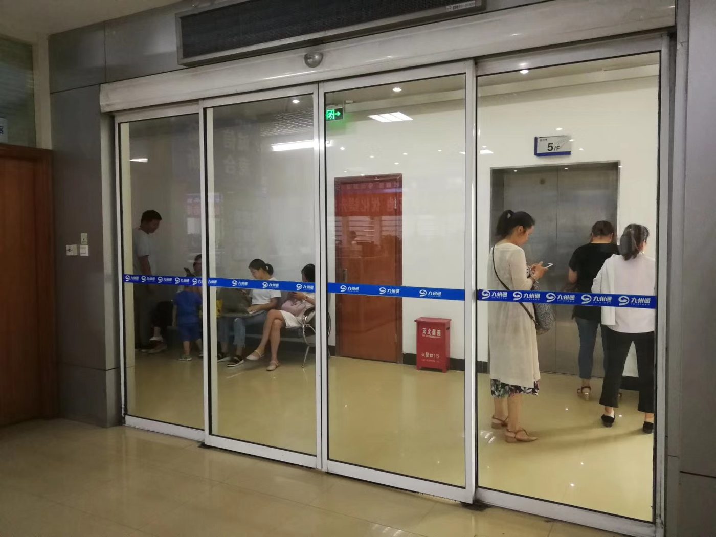 室内玻璃自动门:室内门厅的玻璃平移自动门,白色墙面与吊顶,地面为地砖