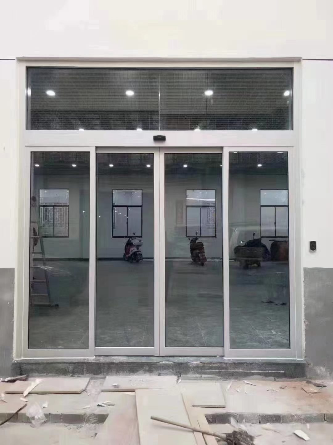 厂房自动门:厂房类建筑的大开口白色框玻璃自动门,门洞宽高较大
