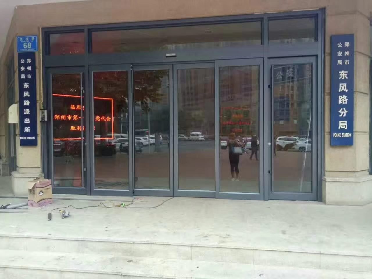 商铺自动门门头：临街商铺的蓝色招牌、门头雨棚与玻璃自动门