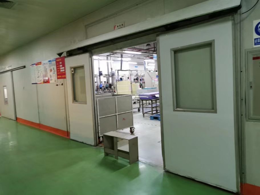 车间自动门:厂房内部人行通道的自动门,绿色工业地坪,周边为生产设备